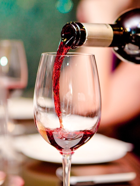 Pouring red wine at Cheese Museum Paris, France.