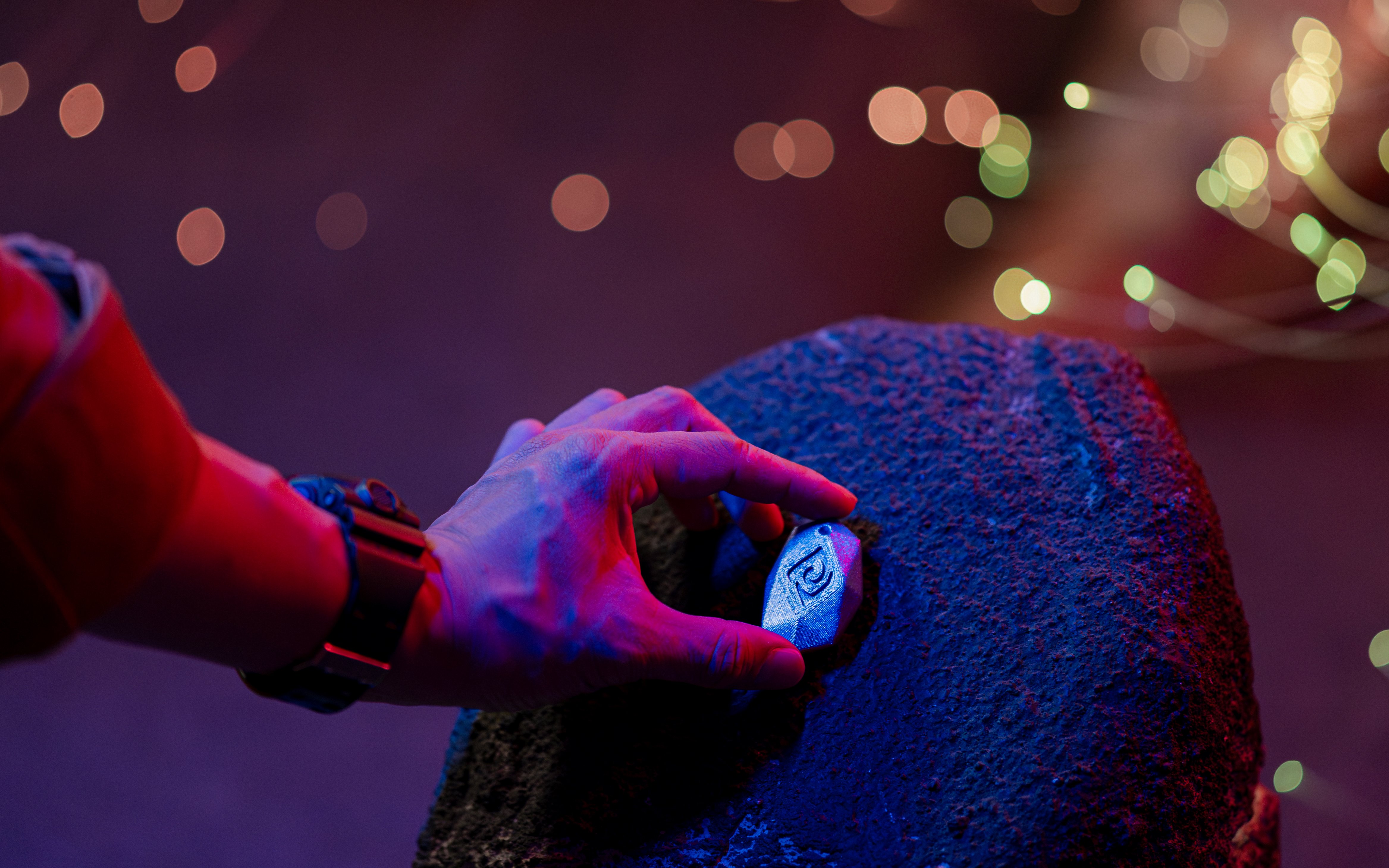 Hand interacting with a wearable device on a rock at Enchanted Forest immersive exhibit.