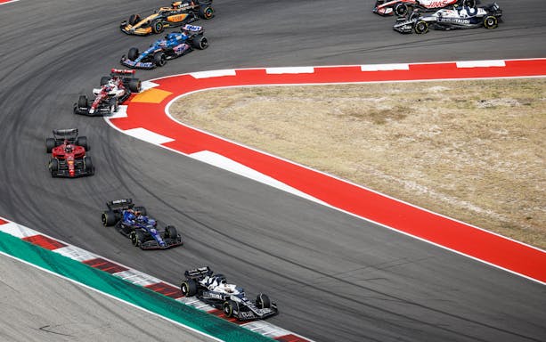 Race cars navigating a turn at Formula 1 USA Grand Prix circuit.