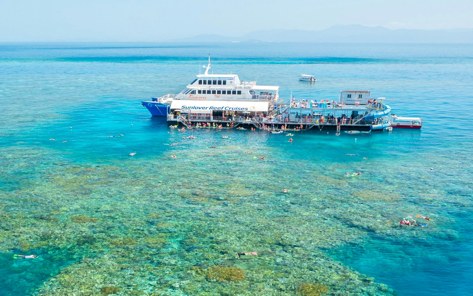 Aerial view of pontoon at Moore Reef, Great Barrier Reef with snorkelers in clear water.