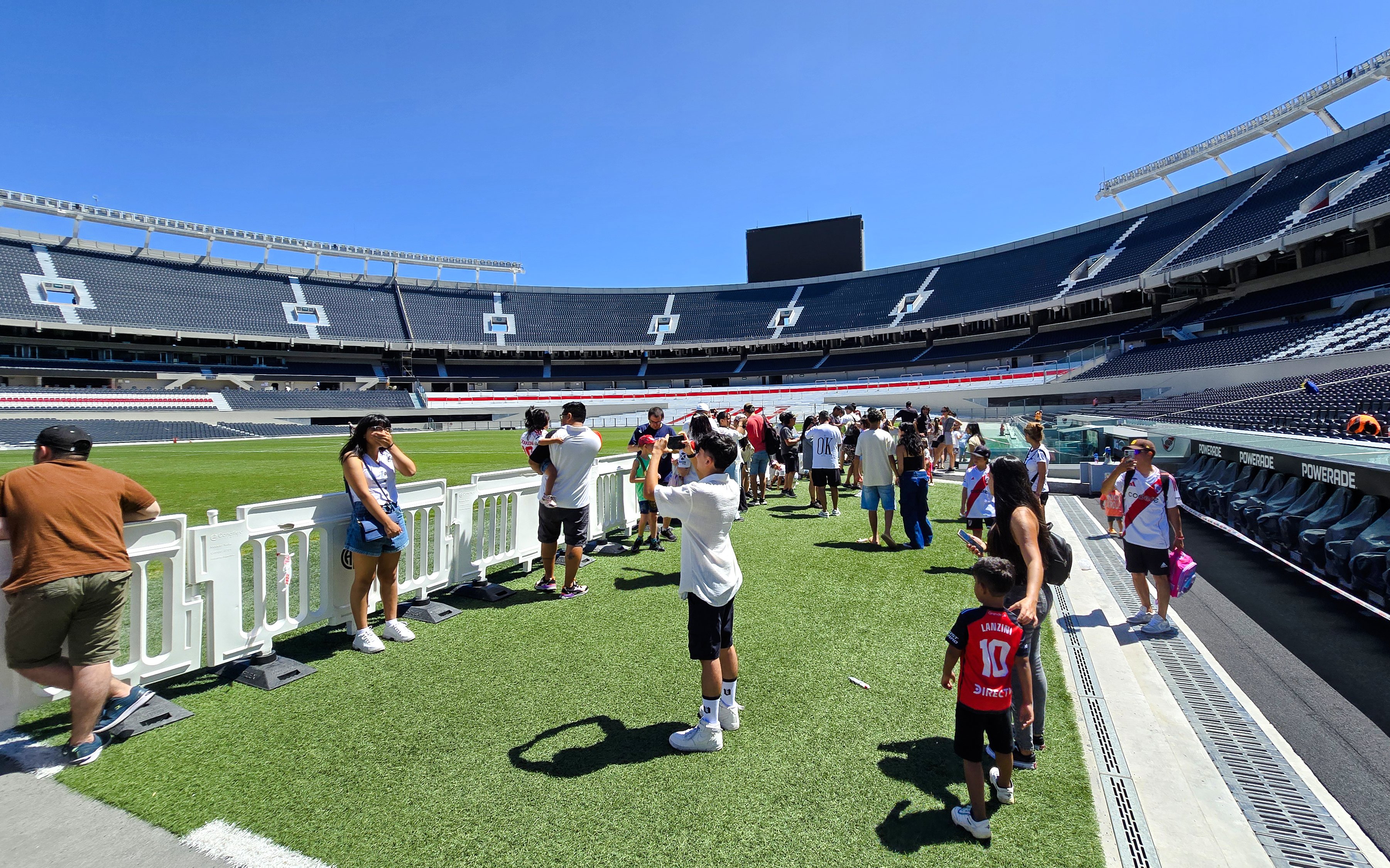 Guests exploring the field at Estadio Monumental Stadium, home of River Plate football club.