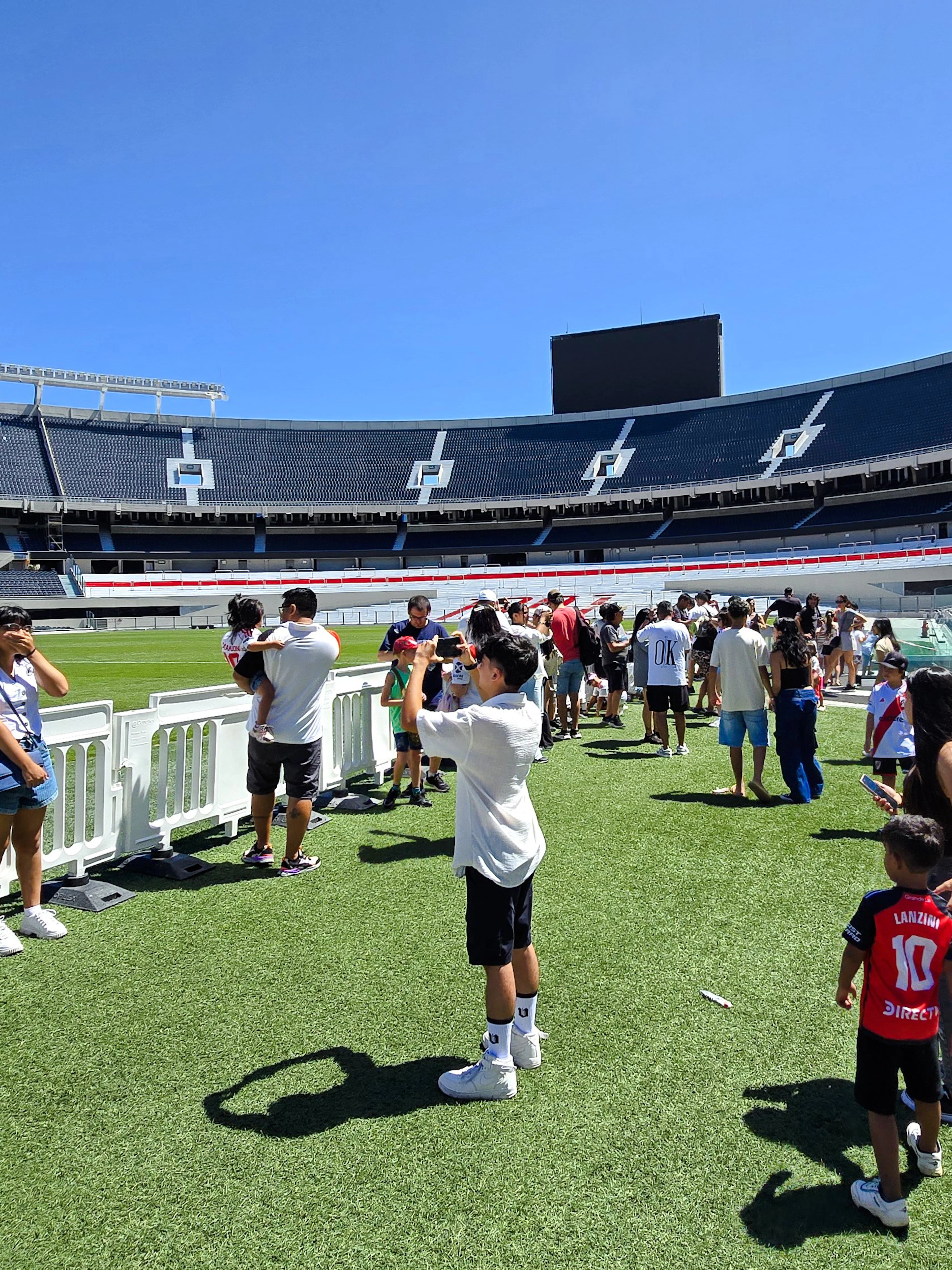 Guests exploring the field at Estadio Monumental Stadium, home of River Plate football club.