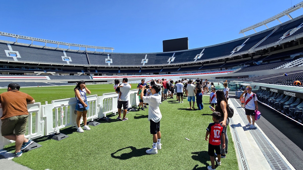 Guests exploring the field at Estadio Monumental Stadium, home of River Plate football club.