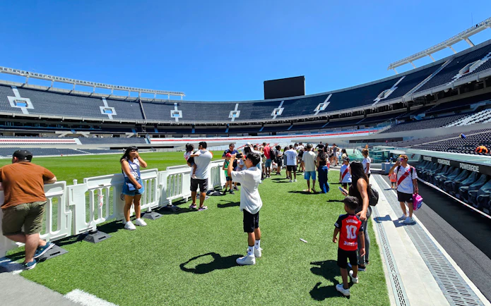 Guests exploring the field at Estadio Monumental Stadium, home of River Plate football club.