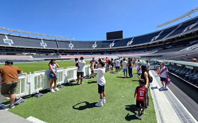 Guests exploring the field at Estadio Monumental Stadium, home of River Plate football club.