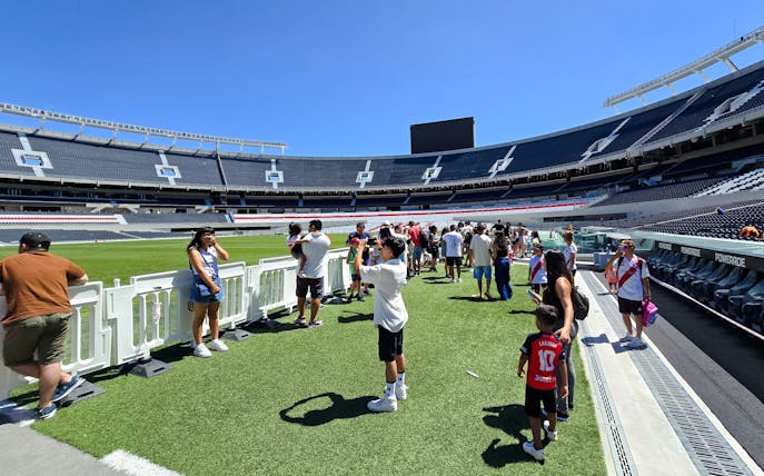 Guests exploring the field at Estadio Monumental Stadium, home of River Plate football club.