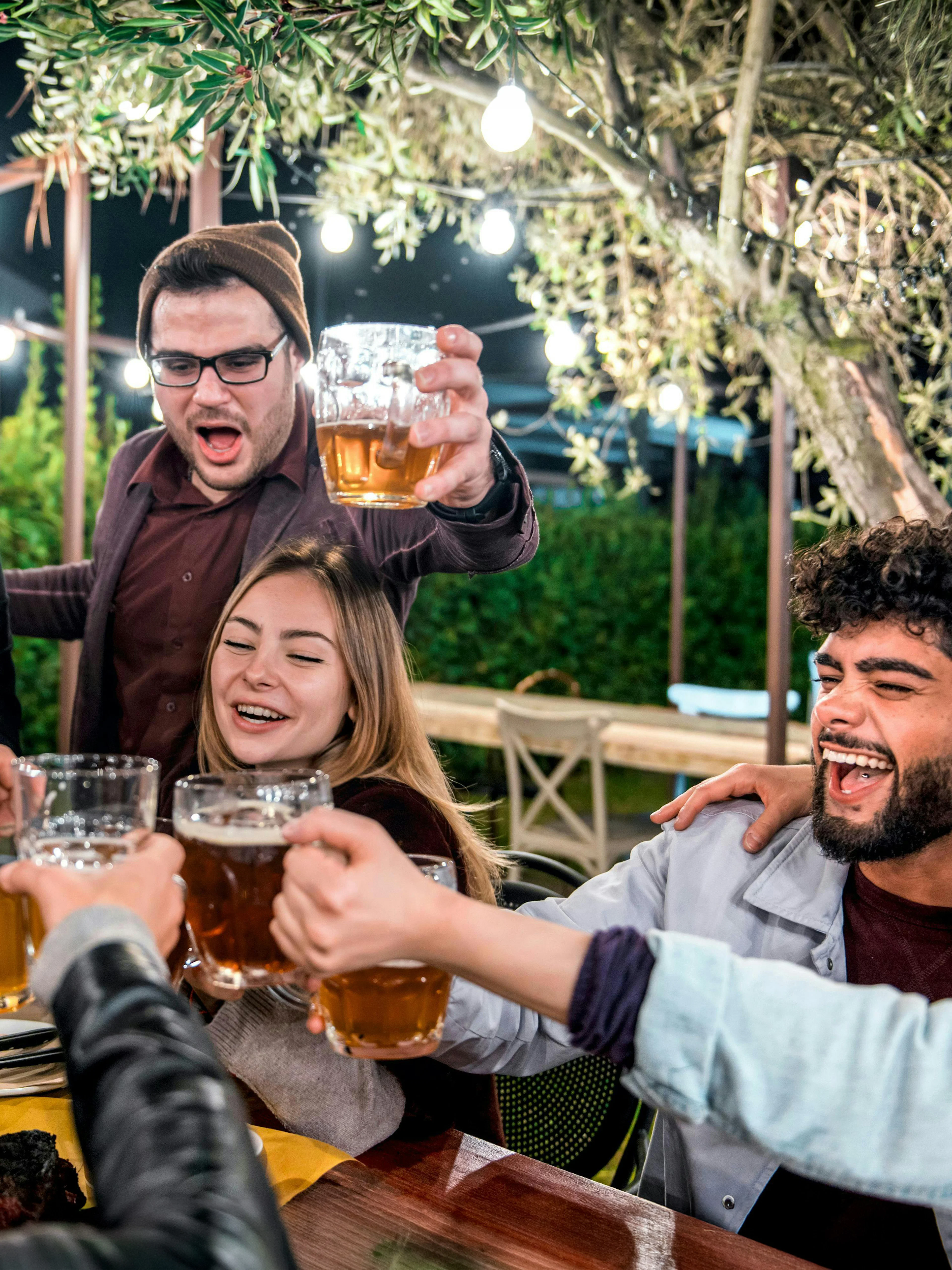 Group enjoying beer at a night gathering outdoors.