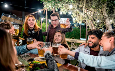 Group enjoying beer at a night gathering outdoors.
