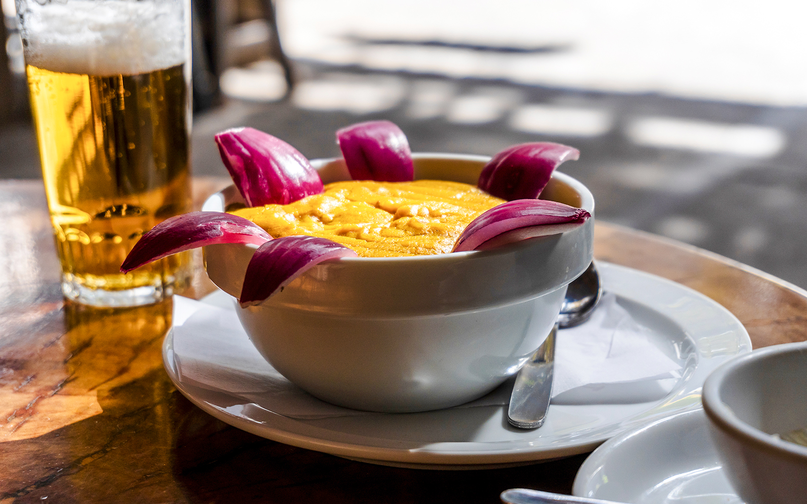 Bowl of gofio mousse with red onion garnish at a Tenerife restaurant table.
