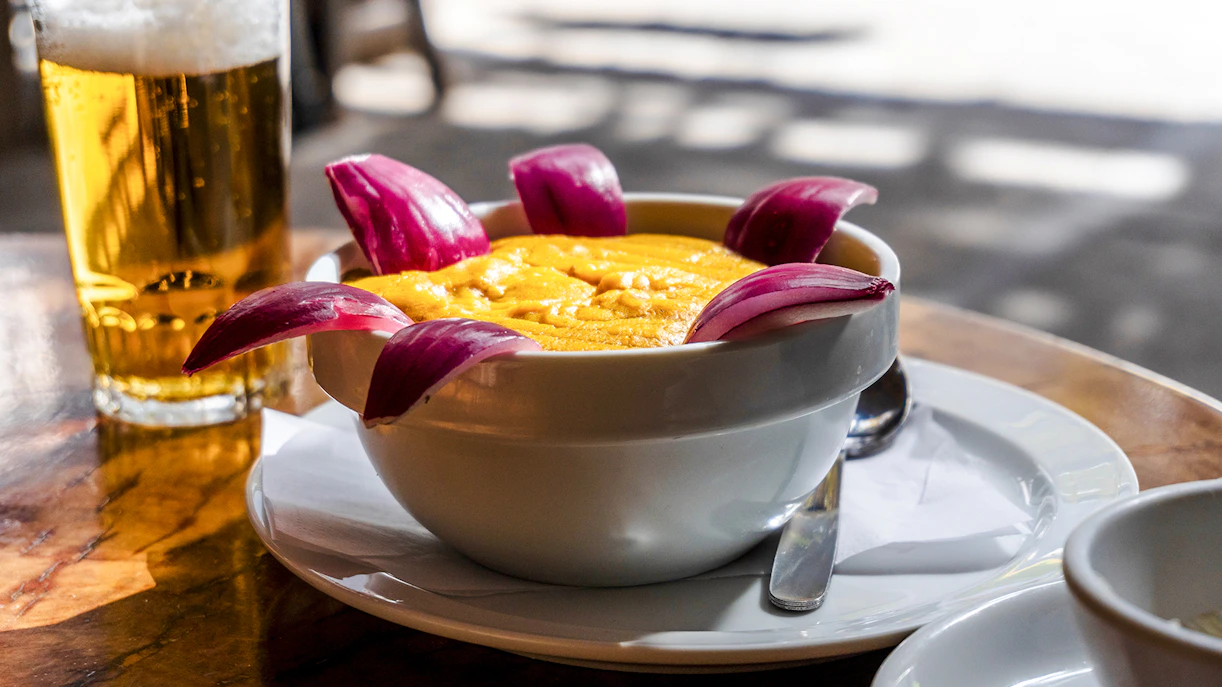 Bowl of gofio mousse with red onion garnish at a Tenerife restaurant table.