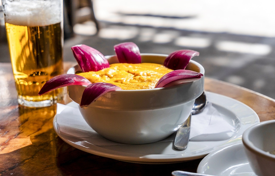 Bowl of gofio mousse with red onion garnish at a Tenerife restaurant table.