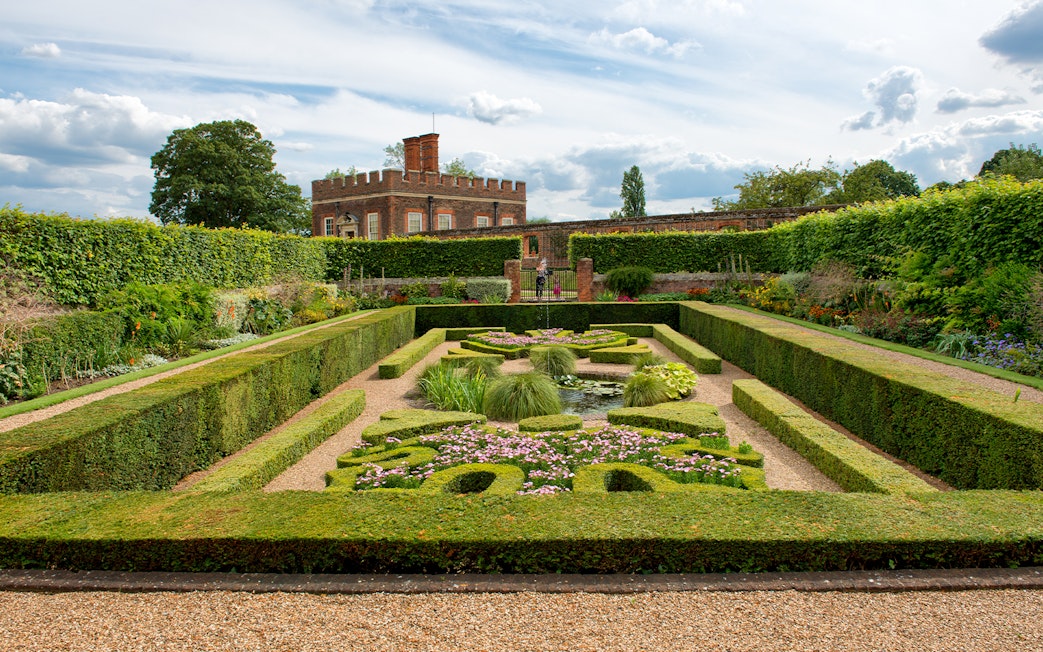 Visitors in Pond Gardens at Hampton Court Palace on a sunny day.