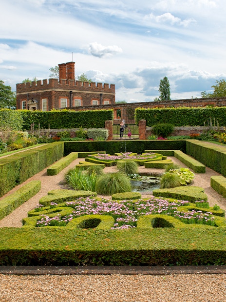Visitors in Pond Gardens at Hampton Court Palace on a sunny day.
