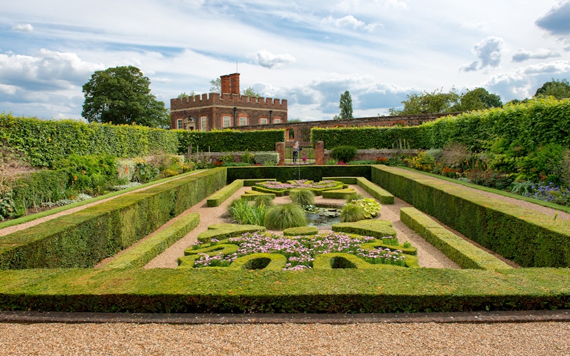 Visitors in Pond Gardens at Hampton Court Palace on a sunny day.