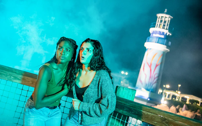 Visitors experiencing Howl-o-Scream at SeaWorld Orlando with lighthouse in background.