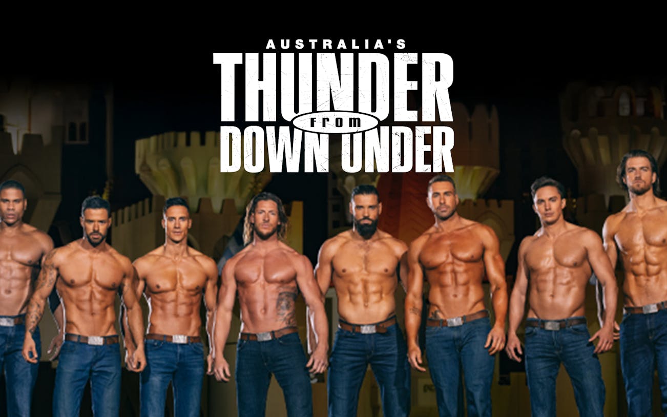 Performers from Australia's Thunder from Down Under in front of castle backdrop.