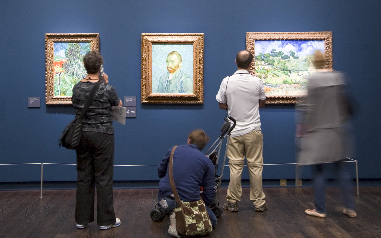 Visitors exploring art exhibits inside the Orsay Museum, Paris, during a guided tour.