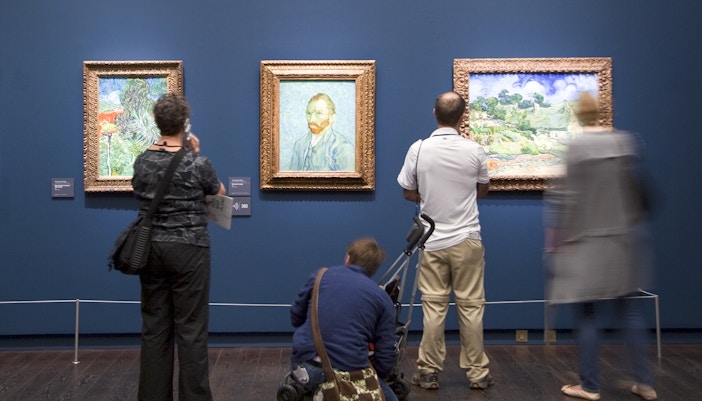 Visitors exploring art exhibits inside the Orsay Museum, Paris, during a guided tour.