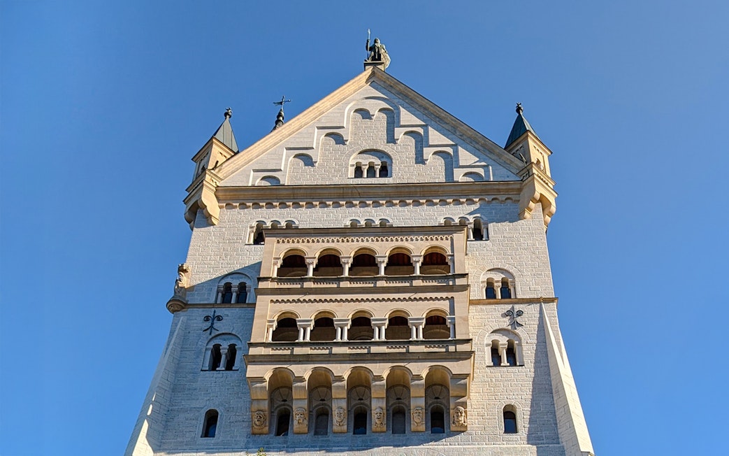 Neuschwanstein Castle facade close-up showing detailed stonework and arched windows.