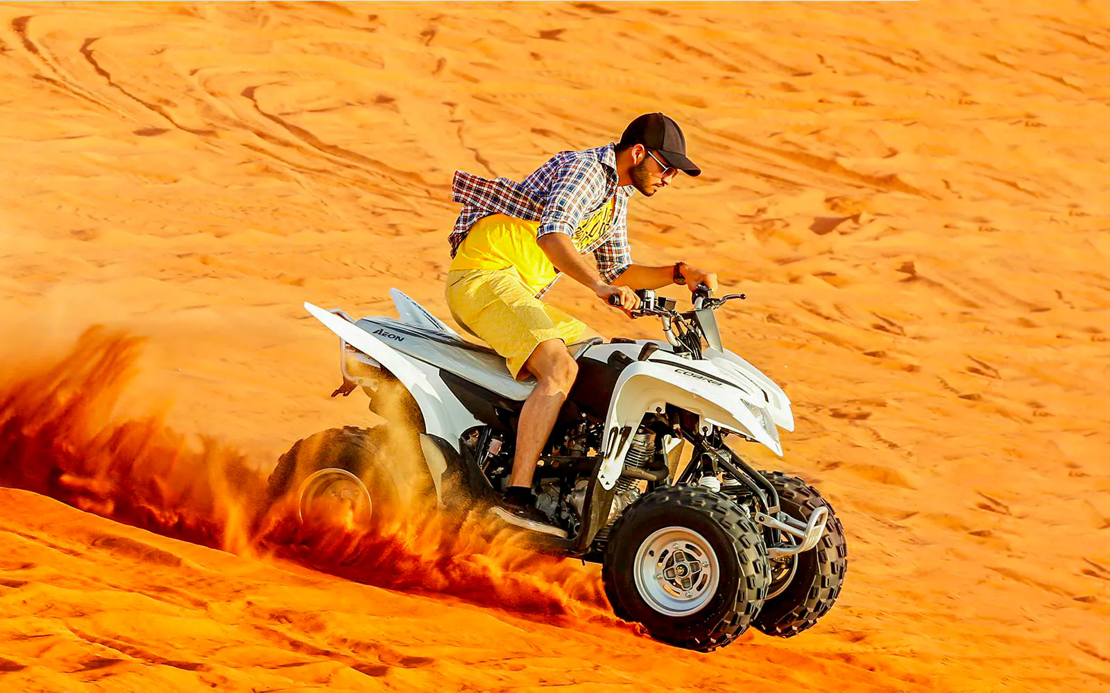 Quad biking on sand dunes during Dubai Desert Safari.