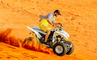 Quad biking on sand dunes during Dubai Desert Safari.