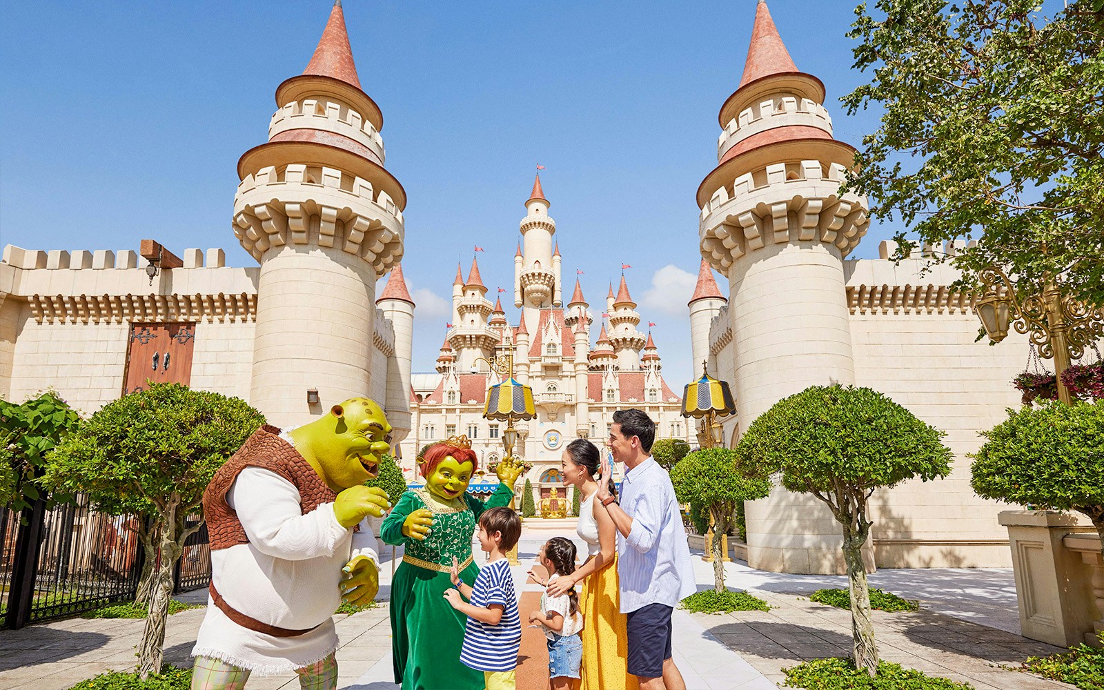 Family meeting Shrek characters at Universal Studios Singapore castle entrance.