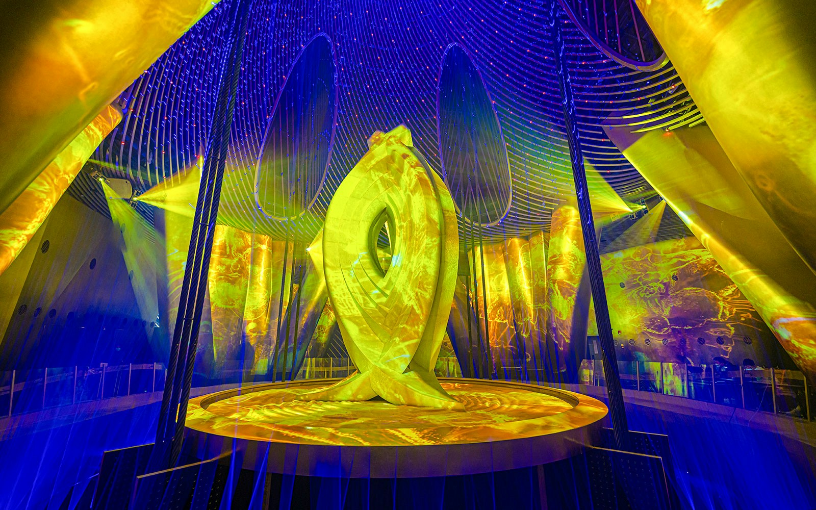 Eye of Shanghai sculpture illuminated by golden light inside Shanghai Tower.