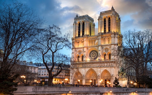 Notre-Dame Cathedral illuminated at dusk, Paris city tour.
