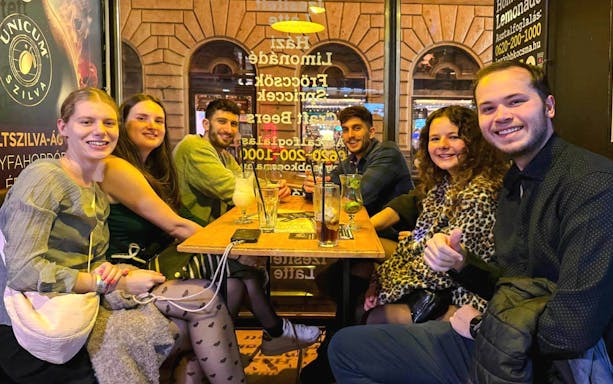 Group enjoying drinks at a pub during a bar tour, Budapest.