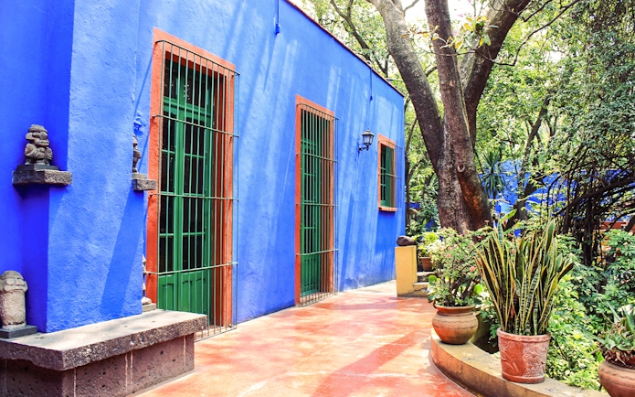 Frida Kahlo Museum exterior with blue walls and garden in Mexico City.