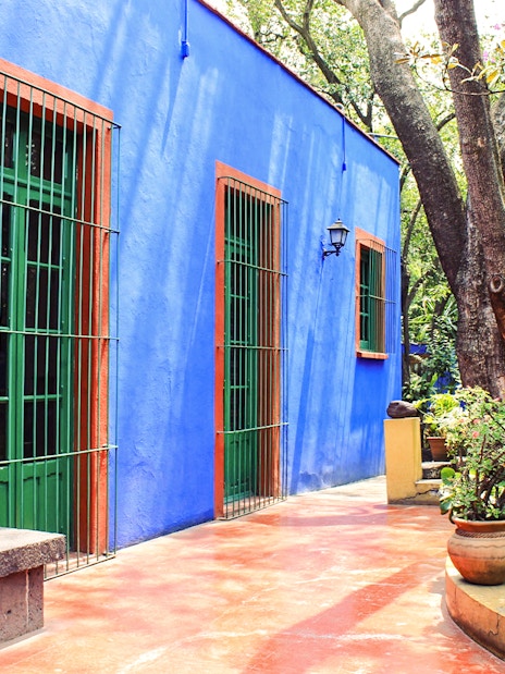 Frida Kahlo Museum exterior with blue walls and garden in Mexico City.