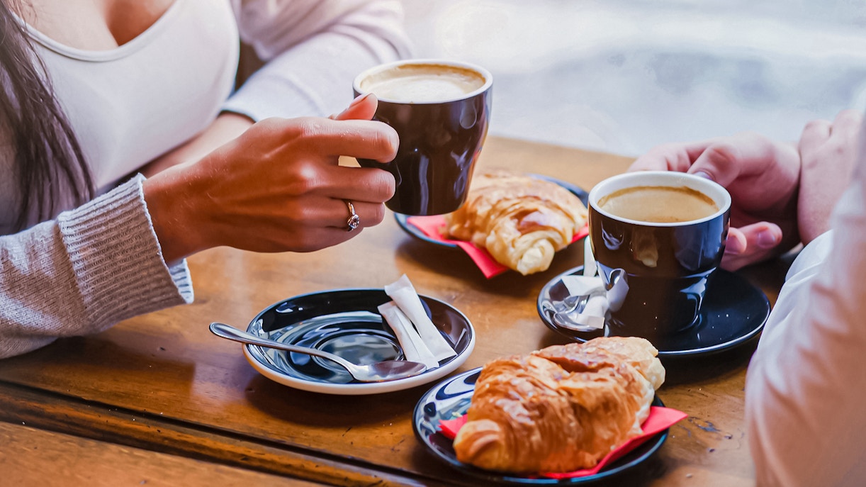 Couple enjoying coffee and croissants.