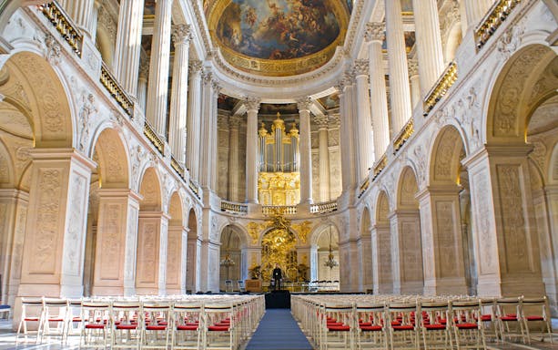 Royal Chapel interior with ornate columns and grand organ, Palace of Versailles, France.