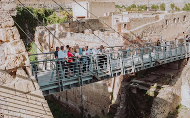 Group of tourists on a bridge at Herculaneum ruins during a guided tour from Naples.