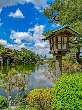 Kenroku-en garden with traditional lantern and pond in Kanazawa, Ishikawa, Japan.