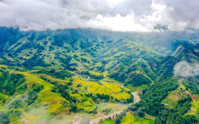 Aerial view of terraced rice fields and mountains in Sapa, Vietnam on a cloudy day.