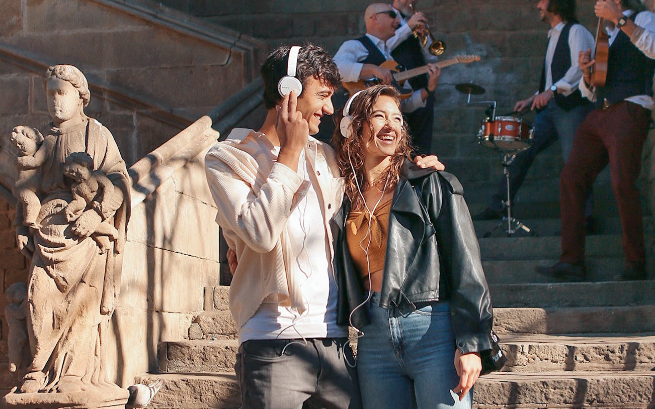 Couple enjoying music on a guided tour in Barcelona with live band and historic architecture.
