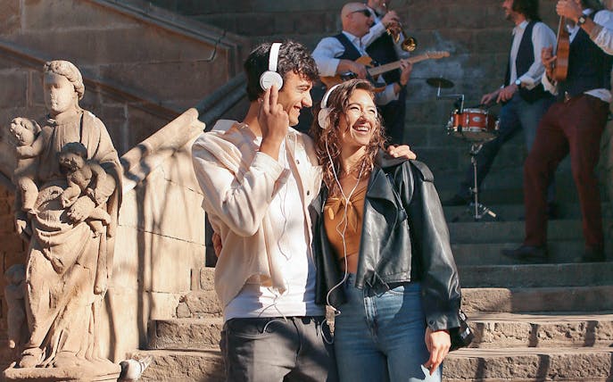 Couple enjoying music on a guided tour in Barcelona with live band and historic architecture.