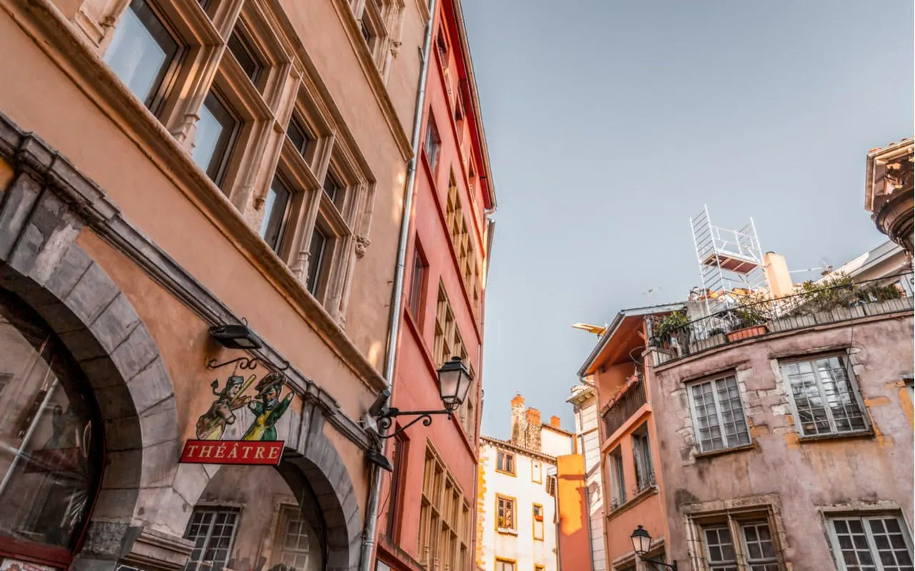 Lyon Old Town street with historic buildings and theater sign.