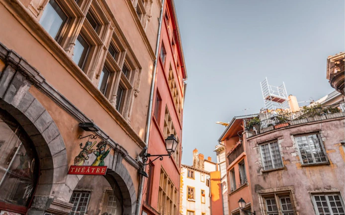 Lyon Old Town street with historic buildings and theater sign.
