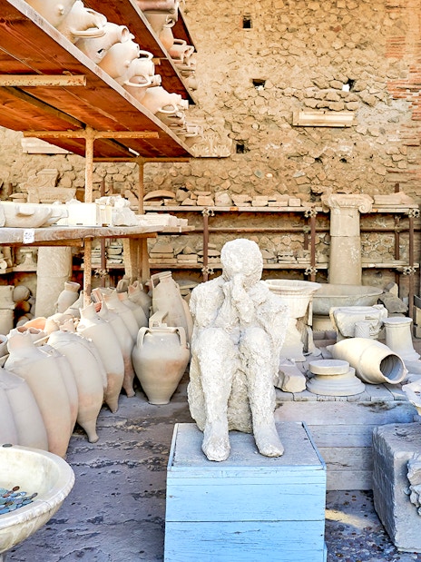 Ancient artifacts and plaster cast in Pompeii marketplace.