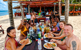 Group enjoying seafood meal on the beach, Islas de San Blas tour, Panama City.