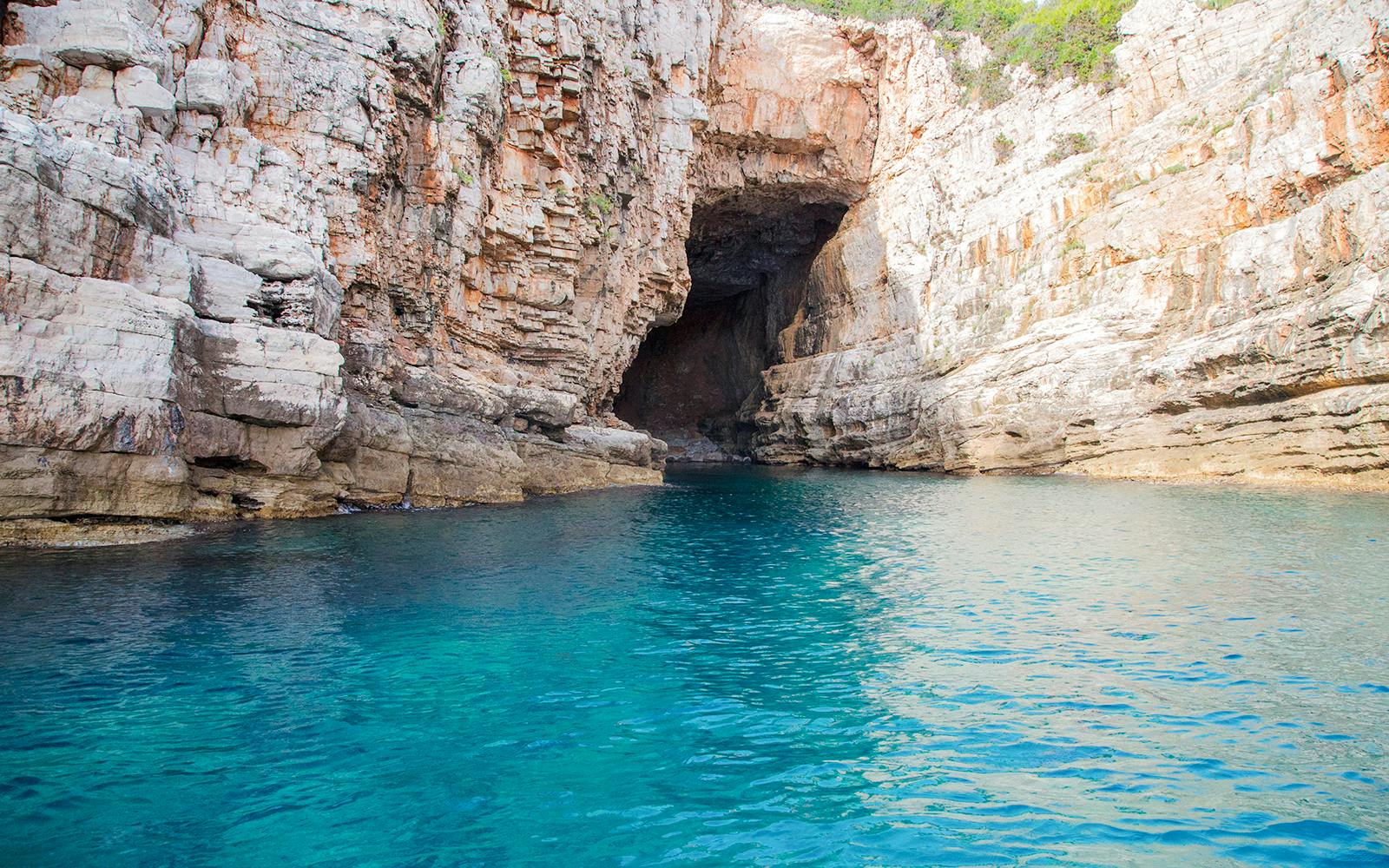 Blue caves near Dubrovnik with clear turquoise water and rocky cliffs.