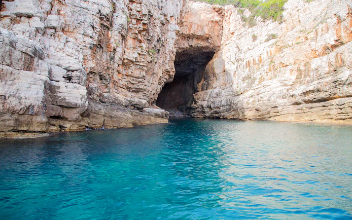 Blue caves near Dubrovnik with clear turquoise water and rocky cliffs.