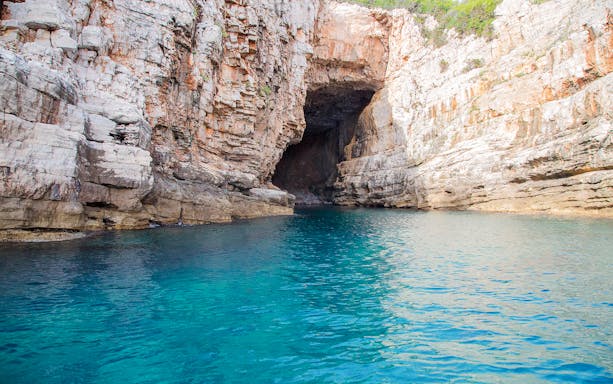 Blue caves near Dubrovnik with clear turquoise water and rocky cliffs.