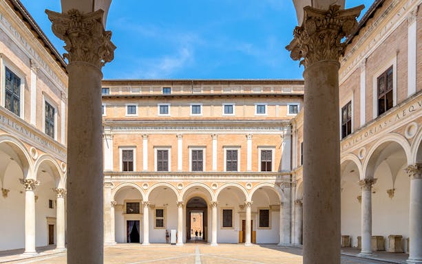 Courtyard of Ducal Palace with arches and columns, Urbino, Italy.