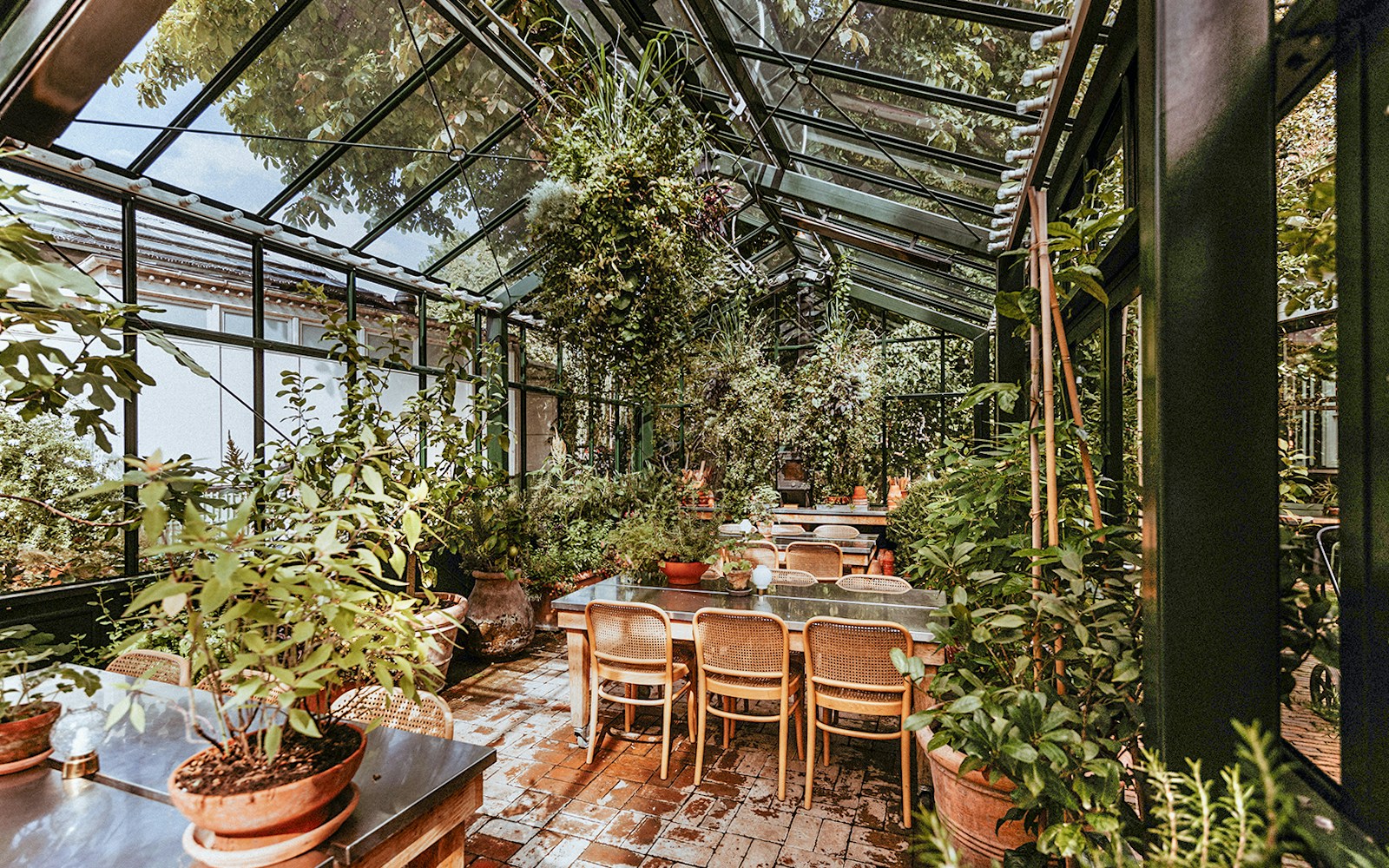 Greenhouse dining area with plants at Tivoli Gardens, Copenhagen.