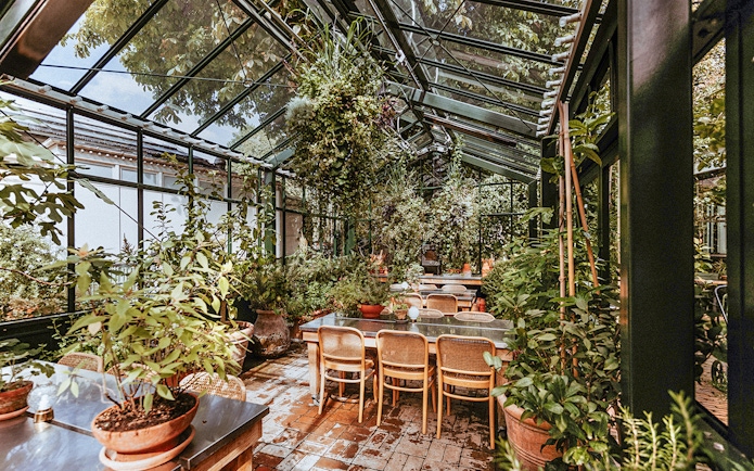 Greenhouse dining area with plants at Tivoli Gardens, Copenhagen.