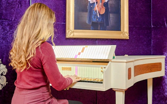 Guest playing a historical keyboard at Mozart Interactive Museum in Prague.