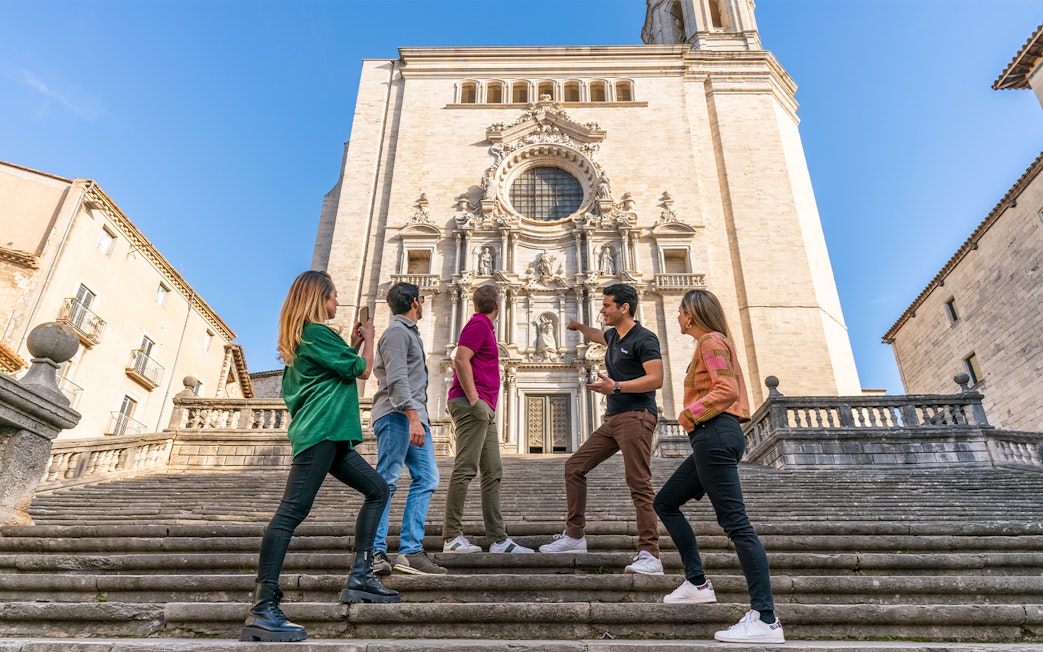 Tourists with guide in front of Girona Cathedral, Spain.